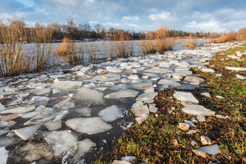 Close up view of ice drift on the frozen river. Melting ice. Flooded road. Concept of spring floods