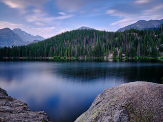 Fototapeta na wymiar Long exposure of Bear Lake surrounded by the pine trees and the Rocky Mountains