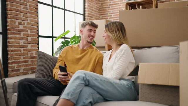 Young couple make selfie by the smarphone sitting on sofa at new home