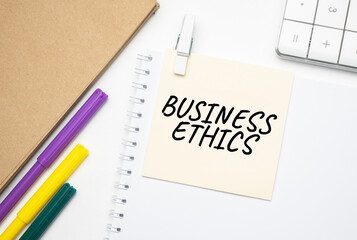 Business Ethics Notebook on laptop keyboard, on light background