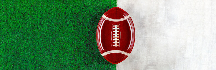 Symbol of american football ball plate on white and green background.