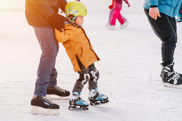 Funny moment fell on the ice skating rink. Activity, Adult, Child, Childhood, Daughter. Mom with baby boy 3-5 years old, learn train, ride winter city rink, ice skating. - obrazy, fototapety, plakaty