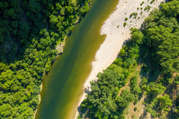 The river flows through the Gorges and forests of Ardeche in Europe, France, Ardeche, in summer, on a sunny day.