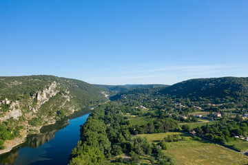 The Ardeche flows near the town of Aigueze and its countryside in Europe, France, Ardeche, in summer, on a sunny day.