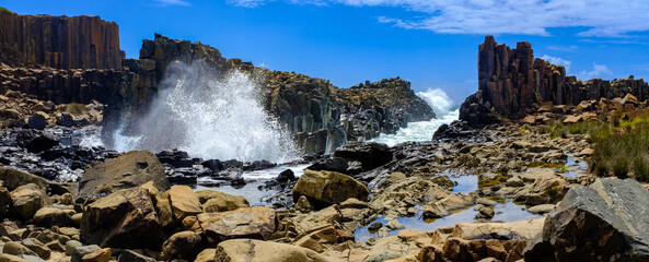 Panorama of waves breaking over basalt rock formations at Bombo Headland quarry, New South Wales...