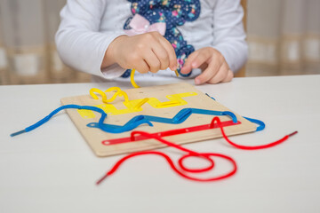 Little girl playing in Montessori educational game. Preschool children and educational toys.