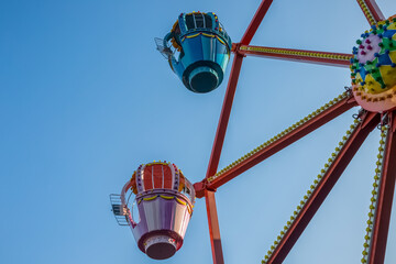 Ferris wheel in an amusement park against a blue sky.