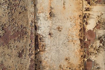 Rostiges Blech mit Nieten und Resten von weissem Lack