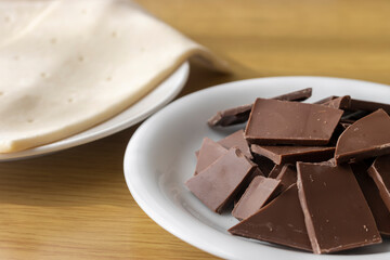 割った板チョコとパイ生地。チョコレートパイ作りをするイメージ