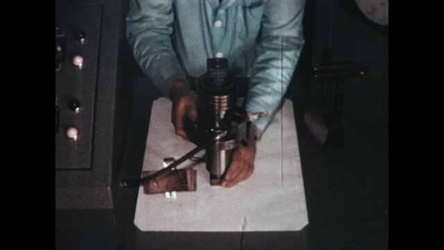 Viewing a Solenoid 1967 - A technician displays an industrial solenoid, turning it for the camera in 1967.