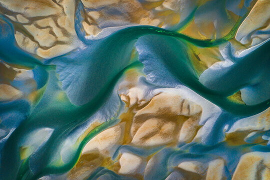 Aerial view of a braided patterns of blue and green form from a river delta. Washington, USA.