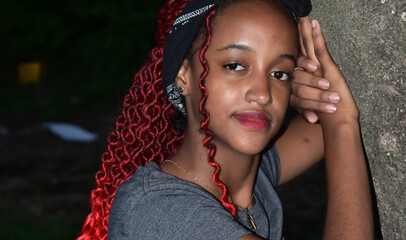 portrait of a girl with red hair leaning on a trunk