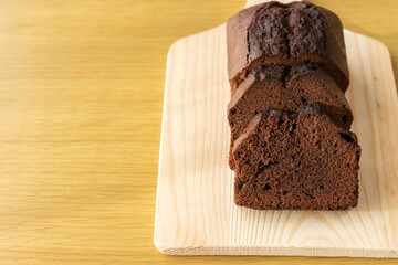 チョコレートパウンドケーキをまな板で切るイメージ。バレンタインデーイメージ。