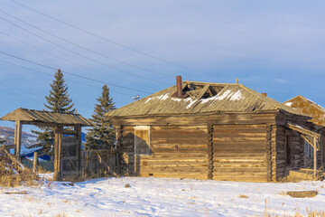 A dilapidated uninhabited dilapidated old wooden house built of logs with a collapsed roof from old...