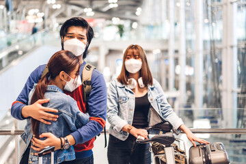 Two young traveler friend embrace in quarantine for coronavirus wearing surgical mask face protection giving big hug together before long travel vacation flight at International terminal airport