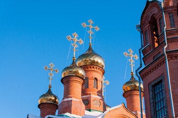 Fototapeta na wymiar Domes with crosses of the Church of St. Innocent of Irkutsk in winter in the city of Khabarovsk against the blue sky