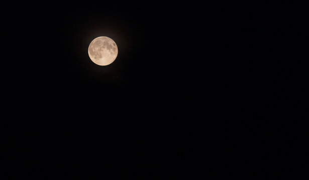 textured yellow moon on black sky background