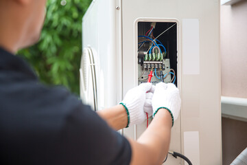 Technician Air-conditioning repairman using measuring equipment checking electric at circuit...