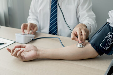 Fototapeta premium Man doctors measured blood pressure, the patient examined the heartbeat, and talked about health care closely. Medical and health care concepts