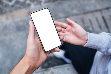 Mockup image of a couple people holding and looking at the same mobile phone with blank desktop...