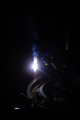 Close-up of a welder working in a workshop. Shallow depth of field. Welding of metal structures. Semi-automatic manual welding. MIG welding.