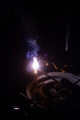 Close-up of a welder working in a workshop. Shallow depth of field. Welding of metal structures. Semi-automatic manual welding. MIG welding.