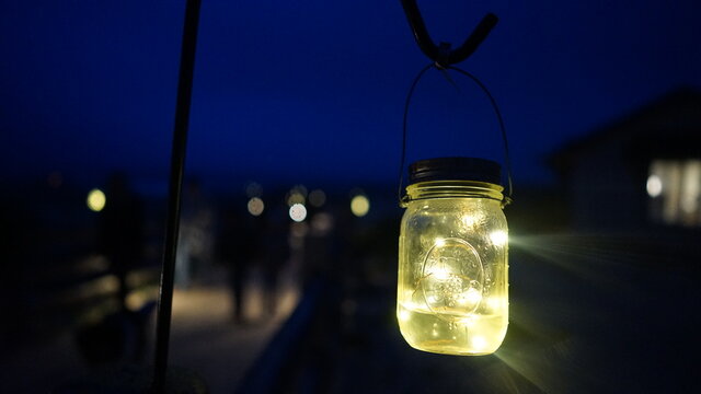 Lit Ball Jar at Night on Beach
