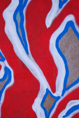 fragment of an abstract background of red and blue graffiti on a concrete wall.
