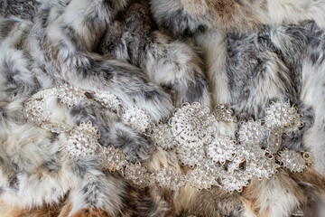 Gray fur texture background decorated with silver metal buckles, handcraft, fashion accessories.
