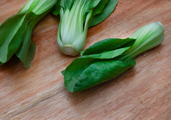 Freshly washed raw Bok choy on wooden cutting board