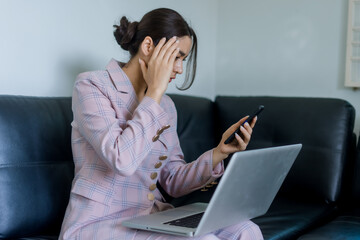 woman sitting on the sofa and holding the phone