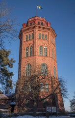Fototapeta na wymiar Famous brick tower Bredablick in a park in on the island Djurgården a sunny and snowy winter day in Stockholm