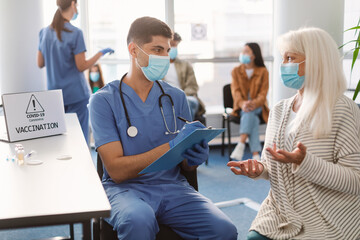 Doctor Talking With Senior Lady Patient Before Appointment In Hospital