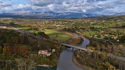 Fototapeta na wymiar Panoramic view of the north of town Sisteron in Provence, France with highway A51, Durance river, meadows, forests and the foothills of the Alps.