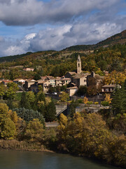 Fototapeta na wymiar Beautiful view of small village with church and traditional buildings, part of town Sisteron, Provence, France, surrounded by colorful trees in autumn.