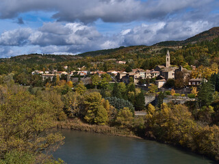 Fototapeta na wymiar Beautiful view of the north of town Sisteron in Provence, France with church and traditional houses surrounded by colorful trees in autumn season.