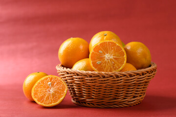 Orange fruit in basket on red background, Chinese New Year concept