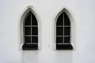 Zwei Fenster in einer weißen Wand in einer Kapelle