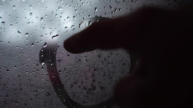 Handwritten drawing of a sad smile on frosted fogged glass.