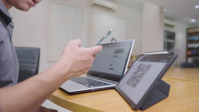 Young Asian male using smartphone scan qr code on the tablet screen registering for  membership online form, digital technology, easy convenience lifestyle multitask worker, online access service