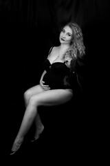 Fototapeta na wymiar Black and white photoshoot of a pregnant woman in the studio