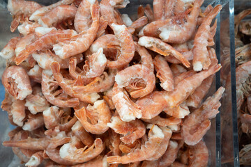 Pink frozen shrimp with ice in a supermarket or fish store. Raw seafood close up background. Fresh frozen prawns, delicacies, seafood concept,