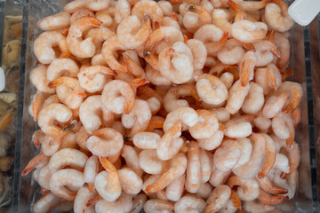 of a heap of frozen orange shrimp. Peeled shrimp, leaving only the tails. Natural seafood...