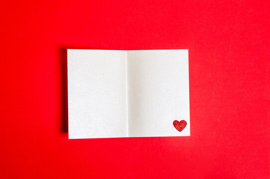 Blank postcard with a shiny heart on a red background for Valentine's Day.