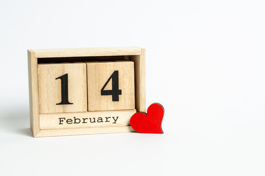 Wooden calendar with date February 14 and red heart on white background with place for text
