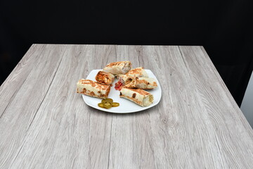 Shawarma kept on a wooden table against a plain black background