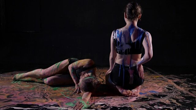 young women are covered by blue and green dyes, art performance