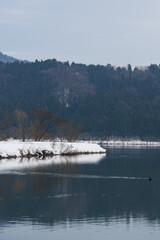 A view of an extremely cold lake covered with snow in the middle of winter.