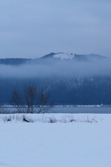 A view of an extremely cold lake covered with snow in the middle of winter.