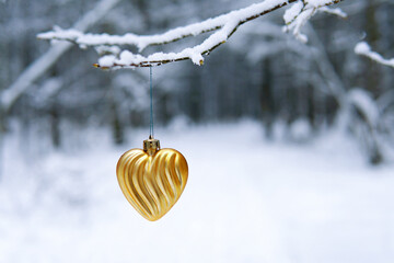 A heart of gold on a branch. New Year's toy. love. Yellow Heart